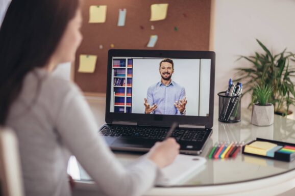 Kobieta tworząca notatki podczas webinaru